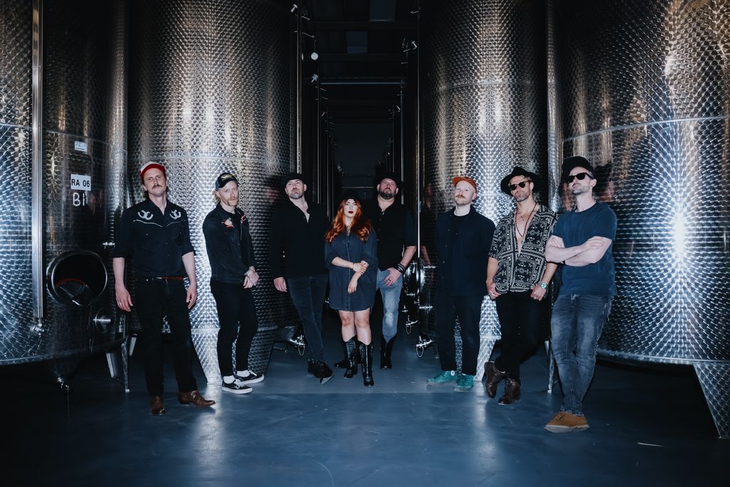 The Reckless Breed, all eight members, standing in a corridor between stainless steel tanks